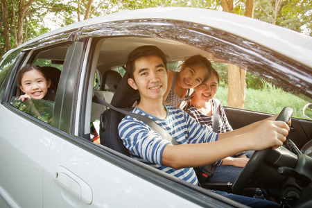 Happy Asian family on mini van are smiling and driving for travel on vacationの写真素材