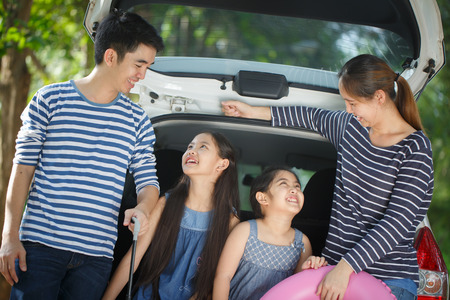 Happy Asian family with van are smiling and preparing for travel on vacationの写真素材