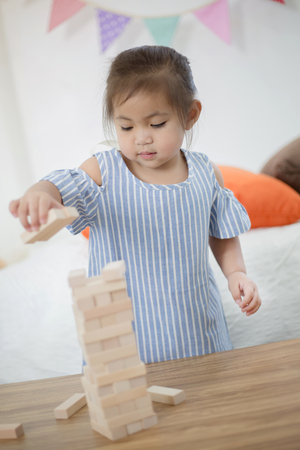 Portrait of happy little Asian girl playing with wooden blocksの写真素材