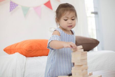 Portrait of happy little Asian girl playing with wooden blocksの写真素材