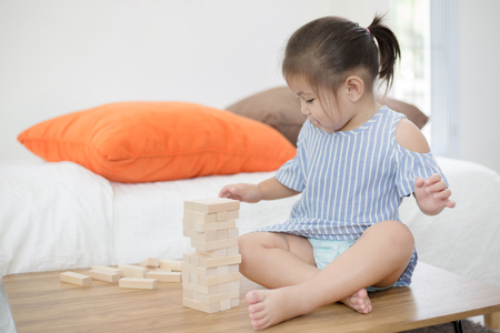 Portrait of happy little Asian girl playing with wooden blocksの写真素材
