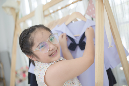 Little Asian student choosing and dressing school uniform prepare to go school, Back to schoolの写真素材