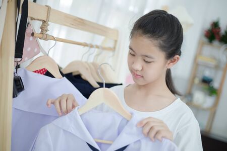 Little Asian student choosing and dressing school uniform prepare to go school, Back to schoolの写真素材