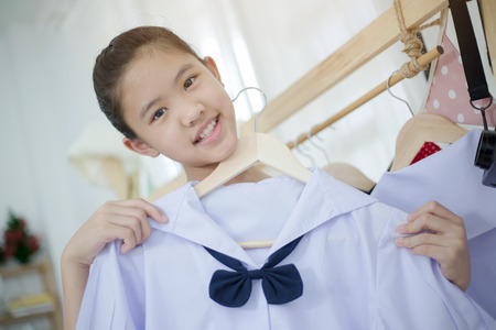 Little Asian student choosing and dressing school uniform prepare to go school, Back to schoolの写真素材