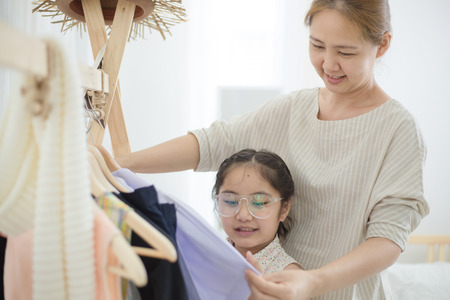 Happy Asian mother helping daughter dressing her's uniform prepare to school, Back to schoolの写真素材
