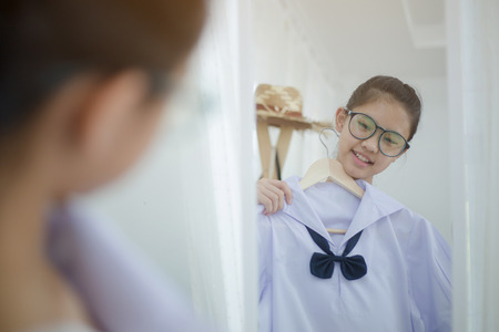 Asian student choosing and dressing school uniform prepare to go school, Back to schoolの写真素材