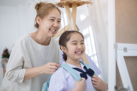 Happy Asian mother helping daughter dressing her's uniform prepare to school, Back to schoolの写真素材
