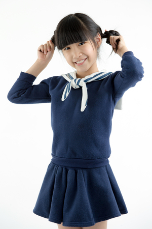 Portrait of Happy long hair little Asian child smiling and dancing isolated on whiteの写真素材
