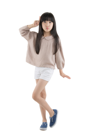 Happy long hair little Asian child smiling and dancing isolated on whiteの写真素材