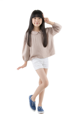 Happy long hair little Asian child smiling and dancing isolated on whiteの写真素材