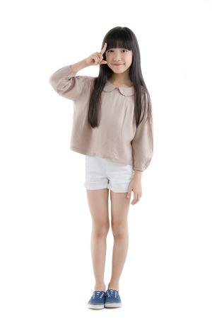 Happy long hair little Asian child smiling and dancing isolated on whiteの写真素材