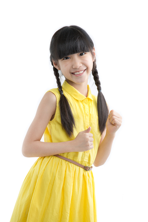 Happy long hair little Asian child smiling and dancing isolated on whiteの写真素材