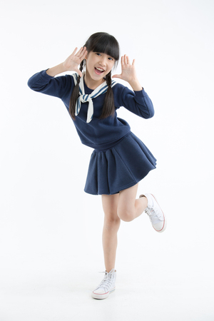 Happy long hair little Asian child smiling and dancing isolated on whiteの写真素材