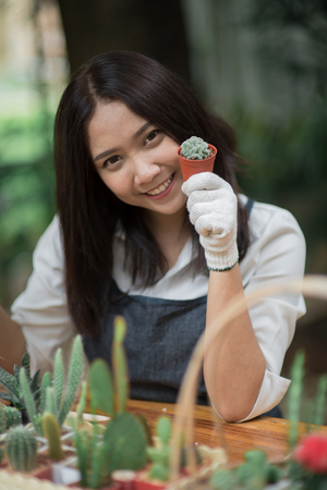 Portrait young Asian girl planting little cactus in a pot for her hobbyの写真素材