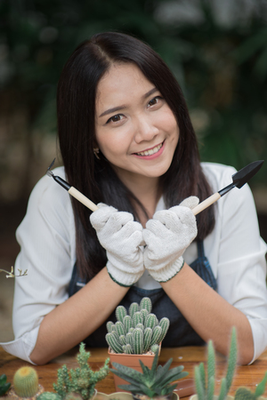 Portrait young Asian girl planting little cactus in a pot for her hobbyの写真素材