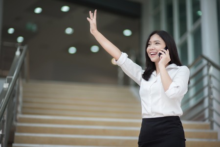 Young Asian woman executive working with a mobile phone in office buildingの写真素材