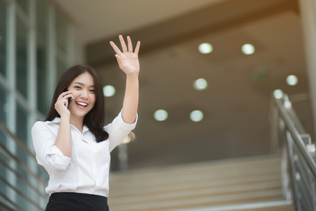 Young Asian woman executive working with a mobile phone in office buildingの写真素材
