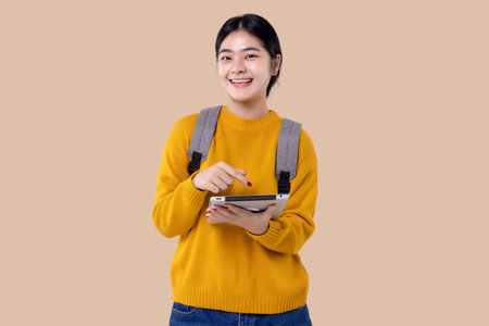 Young Asian student girl using tablet computer on isolated backgroundの写真素材