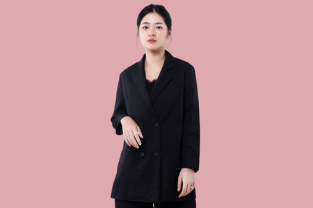 Portrait of Young modern look of Asian business woman standing isolated over pink background.の写真素材