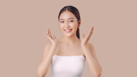 Studio shot of Beautiful young Asian woman with clean fresh skin on brown background, Face care, Facial treatment, Cosmetology, beauty and spa.の写真素材