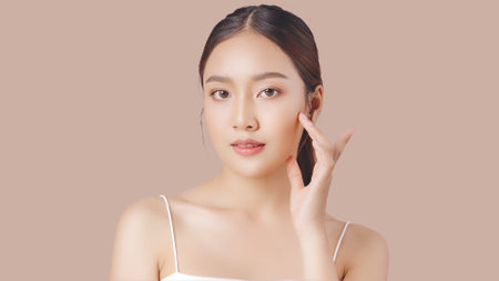 Close up perfect beauty face of young beautiful Asian woman massages her face gently with fingertips. Face cream commercial advertising concept.の写真素材