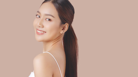 Studio shot of Beautiful young Asian woman with clean fresh skin on brown background, Face care, Facial treatment, Cosmetology, beauty and spa.の写真素材