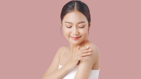 Close up perfect beauty face of young beautiful Asian woman applying moisturizer cream on her shoulder and arm gently.の写真素材