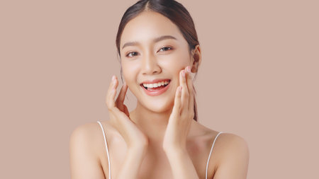 Close up perfect beauty face of young beautiful Asian woman massages her face gently with fingertips. Face cream commercial advertising concept.の写真素材