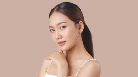 Studio shot of Beautiful young Asian woman with clean fresh skin on brown background, Face care, Facial treatment, Cosmetology, beauty and spa.の写真素材