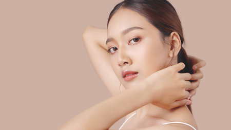 Studio shot of Beautiful young Asian woman with clean fresh skin on brown background, Face care, Facial treatment, Cosmetology, beauty and spa.の写真素材