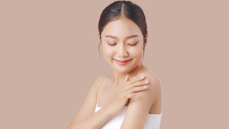 Close up perfect beauty face of young beautiful Asian woman applying moisturizer cream on her shoulder and arm gently.の写真素材