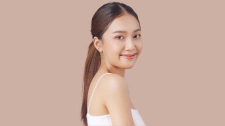 Studio shot of Beautiful young Asian woman with clean fresh skin on brown background, Face care, Facial treatment, Cosmetology, beauty and spa.の写真素材