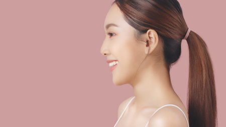 Side face of Beautiful Asian girl isolated on pink background with copy space.の写真素材