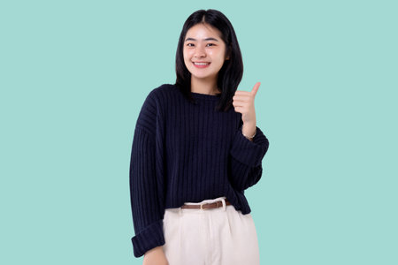 Portrait of young asian woman smiling and showing thumbs up.の写真素材