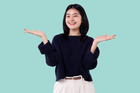 Portrait of a happy young asian woman isolated over blue backgroundの写真素材