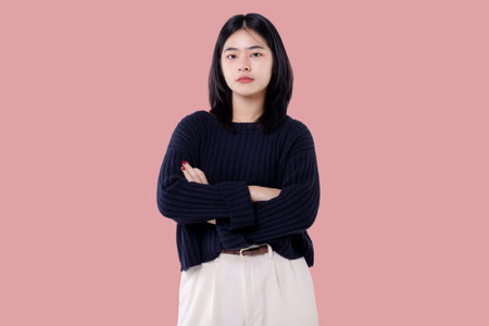 Young Asian girl cross arm isolated on pink background.の写真素材