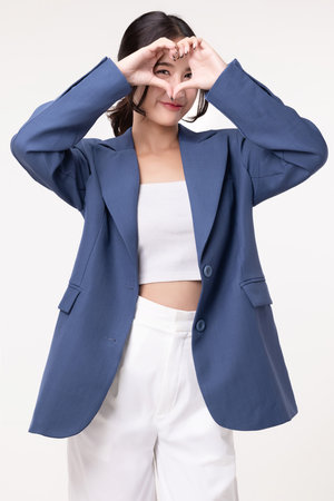 Beautiful young Asian businesswoman making heart shape hand signal on isolated white background.の写真素材