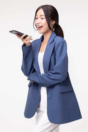 Portrait of happy young business woman talking with AI on smartphone isolated on white background.の写真素材