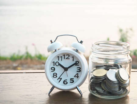 bottle of coins and alarm clock, business conceptの写真素材