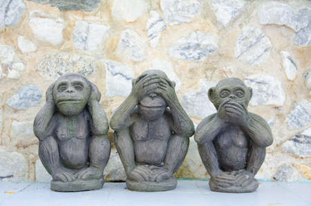 Three wise monkeys with stone background
