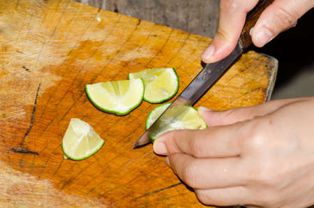 Process cutting green lemon on a board
