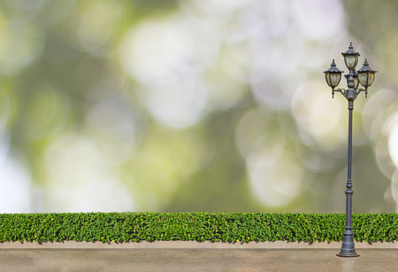 street electric lamp post at green bush fence and concrete floor on green bokeh background : park and outdoor , nature conceptの写真素材