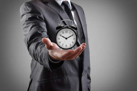 businessman with an alarm clock in a hand  