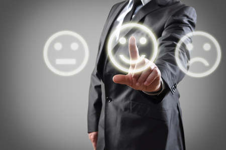 Businessman hand choosing smile on touch screenの写真素材