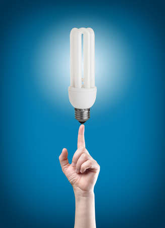 energy saving light bulb on tip of finger on businessman 
