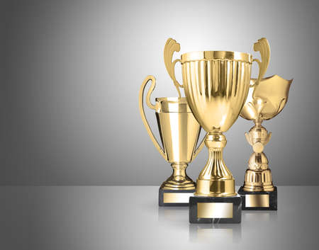 three different kind of golden trophies on gray backgroundの写真素材