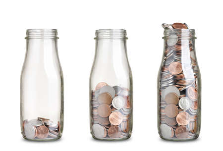 jars with different level of coins isolated on whiteの写真素材