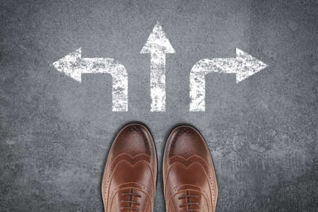 Pair of shoes on a road with arrows