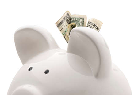 Close-up white piggy bank and US dollars. Isolated on white backgroundの写真素材
