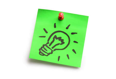 Light bulb on green adhesive notes isolated on white background. Idea conceptの写真素材
